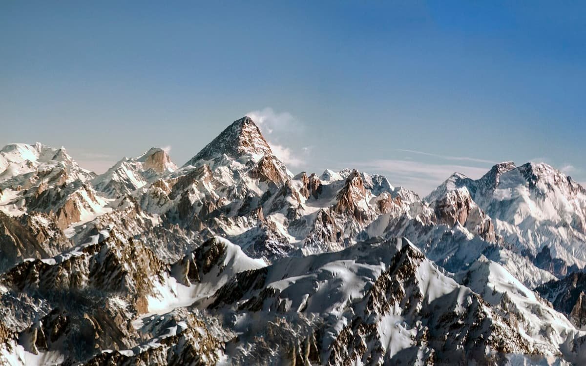 Snow-covered Karakoram peaks seen from the air, K2’s steep pyramid rising above the ranges under a clear sky